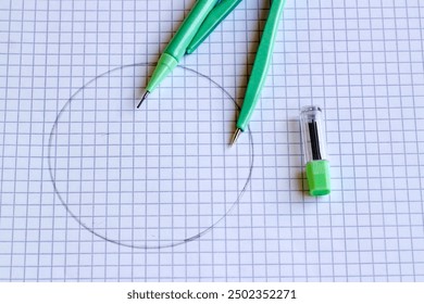 Green compass, on the math notebook, with the circle drawn and the pencil tip - Powered by Shutterstock - Get 15% off with code: PIKWIZARD15