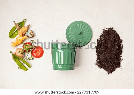 Green compost bin and kitchen leftovers. Recycling scarps, sustainable and zero waste lifestyle concept. Fruits and vegetable garbage waste turning into organic fertilizerd soil. Top view, flatlay