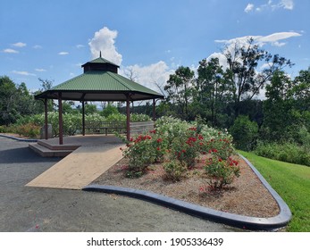 Green corrogared iron roofed Gazebo with red and white roses, white fence, brown wooden posts, green lawn, Nepean Weir, Penrith, NSW Australia - Shutterstock ID 1905336439