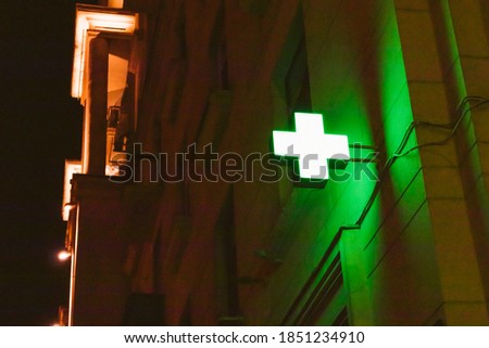 green cross pharmacy on the wall of the building 