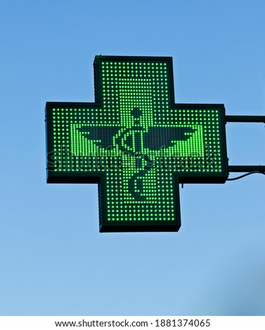Green cross pharmacy store sign with caduceus. Pharmacy sign.