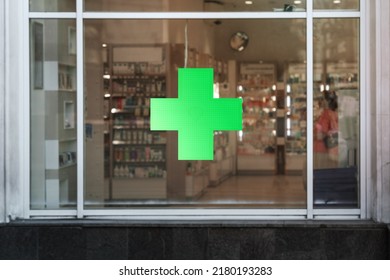 Green cross sign with neon light mounted on pharmacy shop window case outdoor - Shutterstock ID 2180193283
