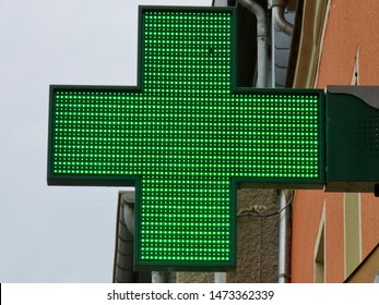 Green Cross Sign Of A Pharmacy Made Of Tiny LED Lights