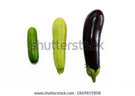green cucumber, zucchini and purple eggplant on a white background