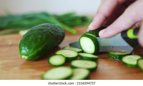 green cucumbers are cut with a knife in the kitchen. healthy food salad vegetables concept. close-up green cucumbers in the kitchen hands close-up cut into slices lifestyle - Powered by Shutterstock