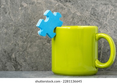 Green cup of coffee and blue puzzle piece. Creativity concept. - Powered by Shutterstock