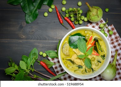 green curry with chicken (Kang Keaw Wan Gai) with brown tablecloth and vegetable on wooden background top view, Thai local food
