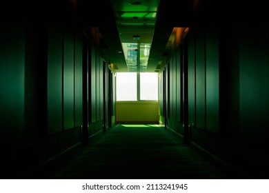 Green, dark, empty corridor in a hotel in perspective. Floor in a hotel. A window in the hallway. The light at the end of the tunnel.