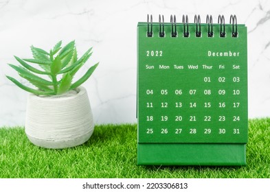 Green December 2022 Monthly desk calendar for 2022 year on grass.