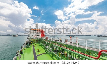 Green deck of the tanker under cloudy sky timelapse. Crane with pipe moving on it by operator. Panoramic view