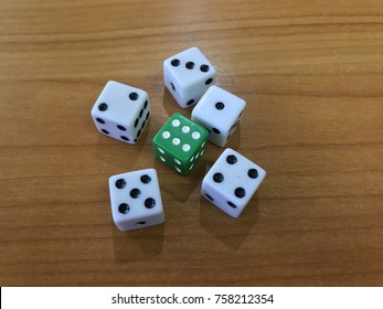 Green dice among white dices on wooden floor, probability check using dices - Shutterstock ID 758212354