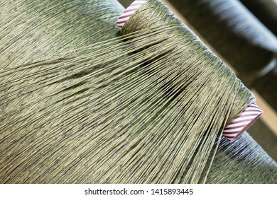 Green Dirty Dark Brown Cotton Wool Threads In A Factory Industrial For Production Of Clothes Materials Yarn Individual Threads Coming Together On A Drum Tube Pipe 