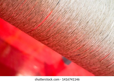 Green Dirty Dark Brown Cotton Wool Threads In A Factory Industrial For Production Of Clothes Materials Yarn Individual Threads Coming Together On A Drum Tube Pipe Bright Red Pink Light Background 