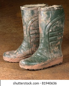 Green Dirty Rubber Boots On Rusty Background