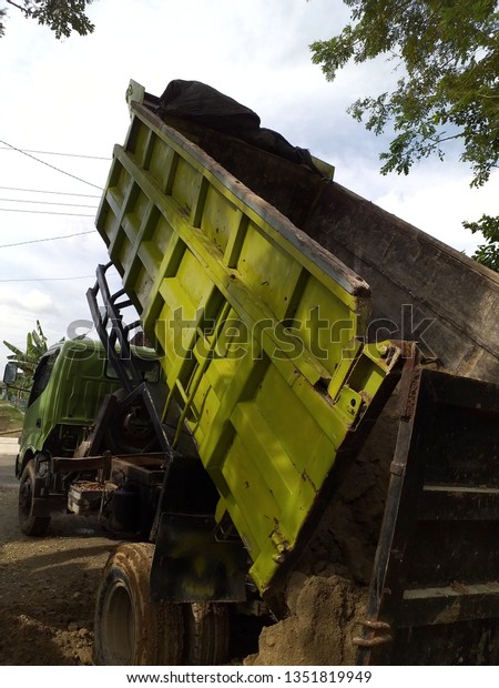  Green Dump truck\
is moving down sand 