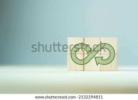 Green eco infinity, net zero, circular economy, renewable enwergy and save the world concept. Sustainable development.  The wooden cubes with green econ infinity on grey background.  ECO banner.