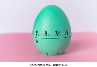 Green Egg Timer On Pink Background. Happy Easter In The Kitchen. Home Related, Home Staying. Free Copy Space. Flat Lay, Top View.