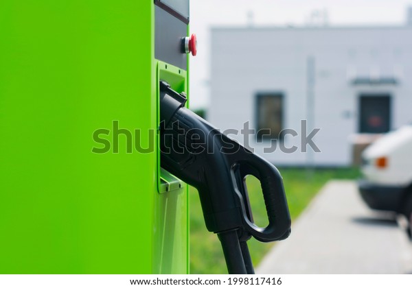 Green\
electric car charging at power station. Charging station for\
electric vehicles against the background of the\
car