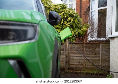 Green Electric Car On Charge At Home