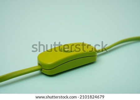 green electric wire with switch on turquoise background
