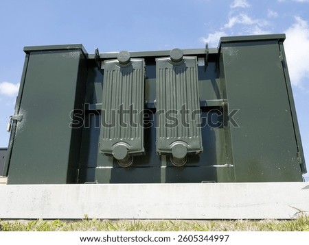 Green electrical transformer unit on concrete pad