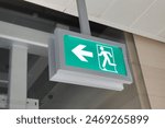 Green emergency evacuation exit direction  sign board help showing the way to escape from building during hazard. closeup side view.