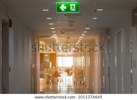 green emergency exit sign in hospital showing the way to escape

