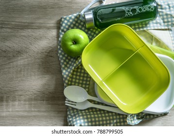 Green Empty Lunch Box Wrapped  On Wooden Table , Top View Or Overhead Shot , Green Food Concept