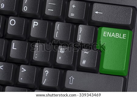 A green ENABLE button on computer keyboard