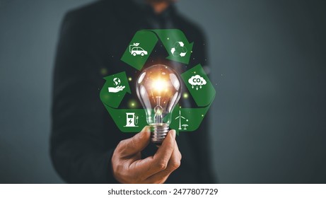 Green energy sustainable development goal, SDG concept. Hand hold light bulb, global network with recycle sign, environmental icon. Carbon credit technology management. Environment friendly business - Powered by Shutterstock