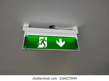 A Green Escape Route Sign On A Hotel Ceiling 