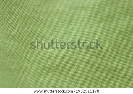 Green fabric with cotton texture, light green for backgrounds, textures, banners, slides and backgrounds.