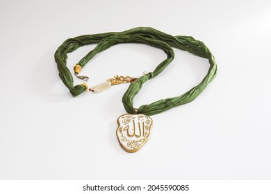 Green Fabric Necklace With Allah Writing On The End. Isolated White Background