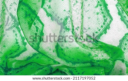 green fabric with snakeskin pattern, background texture of bright green fabric close up. background, texture, pattern