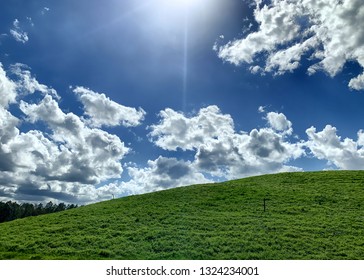 Green Field Covering Old Landfill With Methane Vents On A Blue Sky Day