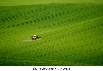 Green Field With Red Tractor And Trails