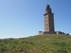 Green Field And Tower Of Hercules In European A Coruna City At Galicia District Of Spain, Clear Blue Sky In 2019 Warm Sunny Summer Day On September.