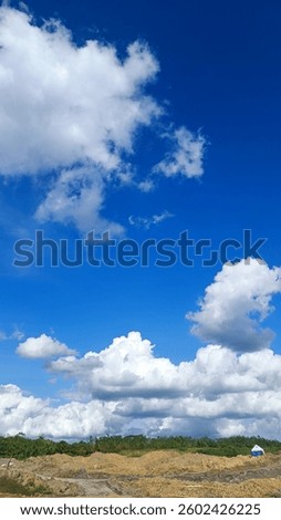 Green field under a dramatic sky with clouds. Serene and natural landscape, perfect for backgrounds and nature-themed designs