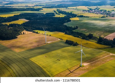 Green Fields And Forests Landscape With Wind Power Plants - Bird Eye Perspective