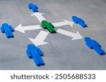 A green figure at the center surrounded by blue figures with arrows. Delegation concept. Green figure distributes tasks or responsibilities to others.