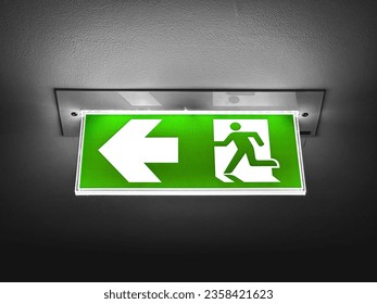 A green fire exit sign is placed on the ceiling along the dimly lit corridor.