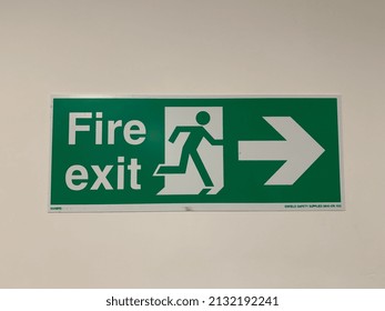 green fire exit sign and symbol with direction arrow, emergency evacuate