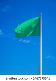 Green Flag Isolated Waving On The Sky