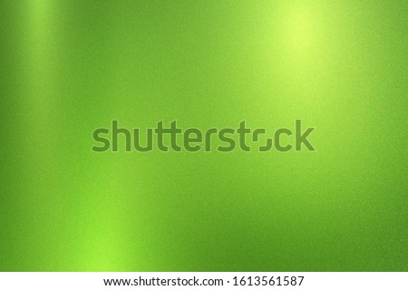 Green foil metallic wall with glowing shiny light, abstract texture background
