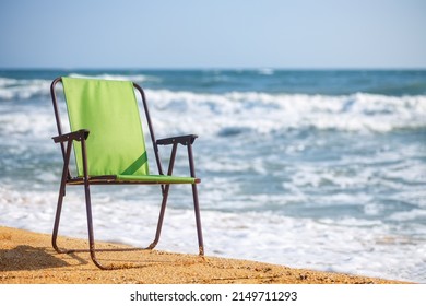 Green Folding Chair On The Sea Beach. Summer Vacation Concept