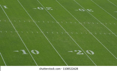 A green football field background with white numbers.