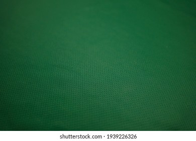 Green Football Jersey Clothing Fabric Texture Sports Wear Background, Close Up. Sport Clothing Fabric Texture Background. Top View Of Cloth Textile Surface. Green Football Shirt. 