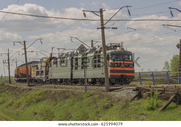 Green freight\
train transports cargo by\
rail.