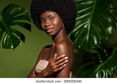 Green and fresh. Beauty portrait of young beautiful african american woman with posing against green exotixc plants  background. Natural skin care concept