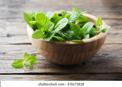 Green fresh mint om the wooden table, selective focus